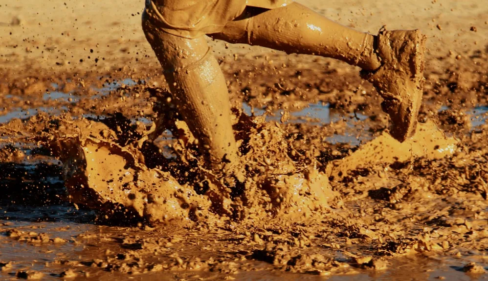 person running through a mud puddle